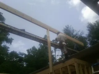 Carpenter setting a ridge beam over a new addition frame — Ice Dam Removal by Roofing Brothers in Stevensburg
