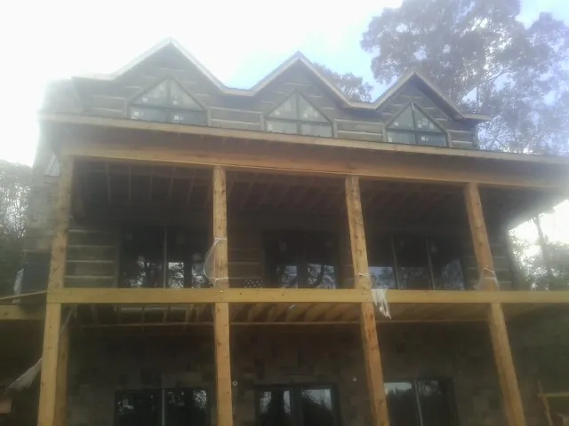 Dormers and porch framing on a large log home under construction — Roof Coating work by our crew in Stevensburg